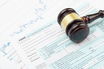 Wooden judge's gavel over 1040 US Tax form