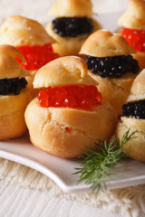 Delicious profiteroles with red and black caviar, vertical