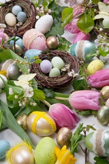 Assorted eggs and flowers for Easter on white
