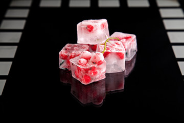 Ice cubes with berries on black background