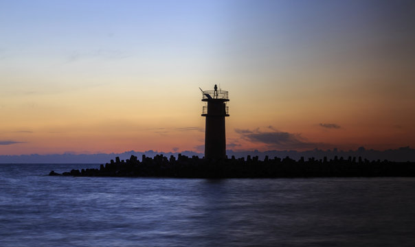 Seascape at sunrise, Lighthouse on the coast.