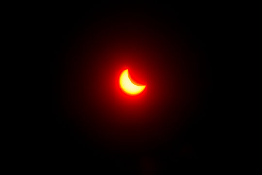 partial solar eclipse through the filter, the red sun