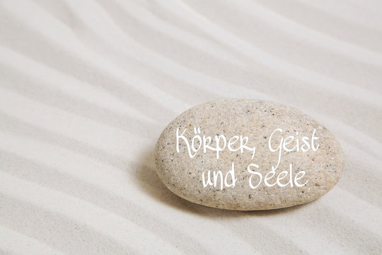K&ouml;rper, Geist und Seele: Sand mit Stein und Text Hintergrund