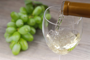 Pouring white wine and grape