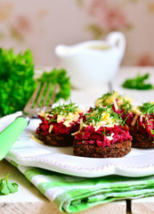 Canape from fried rye bread with beetroot,carrot,garlic and chee