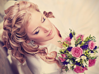 Beautiful blonde bride with a bouquet of flowers