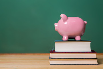 Piggy bank on top of books with chalkboard