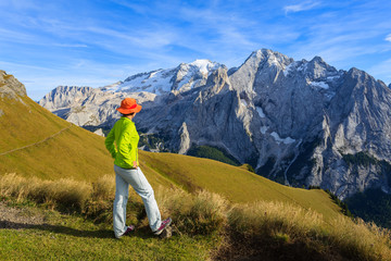 Woman tourist on hiking trail in Dolomites Mountains, Italy