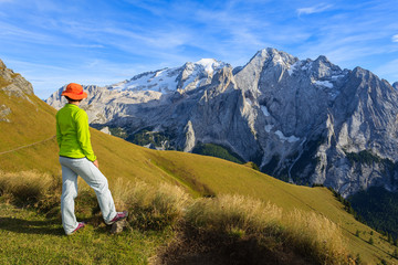 Woman tourist on hiking trail in Dolomites Mountains, Italy