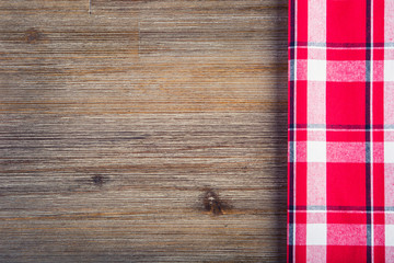 Top view of checkered napkin and teflon pan on wooden table. 