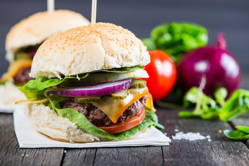 Homemade burger with vegetables on wooden table