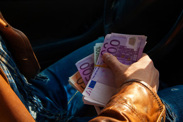 close-up photo of male hand holding a wads of money