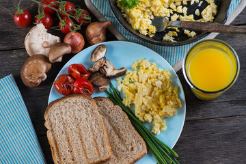 serving healthy brunch, scrambled egg with vegetables, from abov