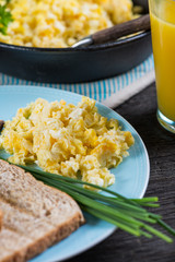 eating healthy breakfast, scrambled egg with chives and fresh ju