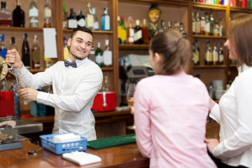 Fototapeta na wymiar Young bartender and smiling women