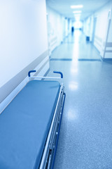 Long corridor in hospital with surgical gurney.