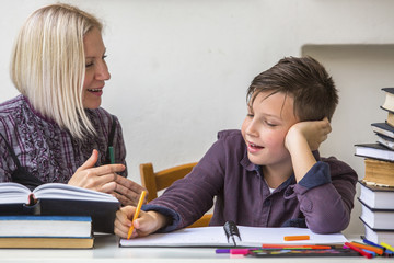 Junior student does homework with the help of his tutor..