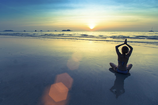 Yoga woman meditating on the ocean beach.