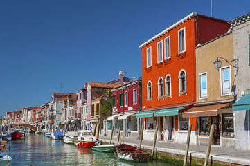 Fototapeta na wymiar Murano island canal, colorful houses and boats, Venice, Italy.