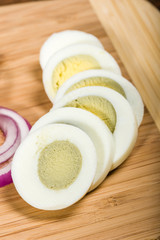 Sliced hard boiled egg on cutting board