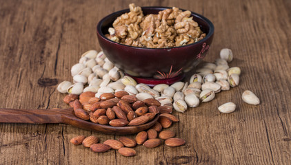 Almonds, pistachios and walnuts in wooden bowl