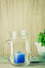 Blue candle in bottle glass