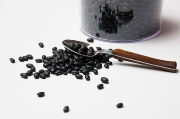 black beans with a spoon on white background