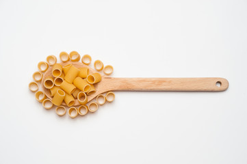 A wooden spoon with pasta on a white background