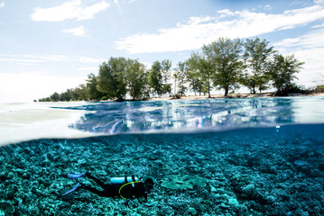 scuba diver below island kapoposang underwater bali lombok
