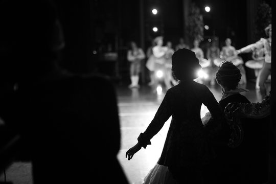 Silhouettes of actors waiting in the wings