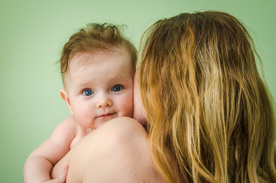 Naked Girl Baby On The Shoulder Of Mothers On A Green Background