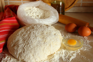 Yeast dough, eggs, and flour on the table.