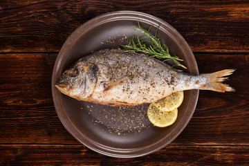 Grilled sea bream fish on plate.