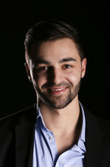 young fashion man model portrait on black background