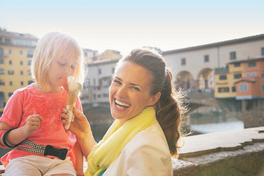 Fototapeta Portrait of smiling mother and baby girl eating ice cream