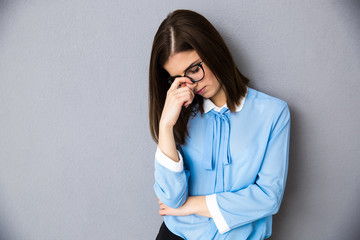 Pensive businesswoman over gray background