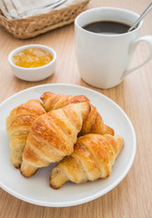 Croissants with jam and coffee cup