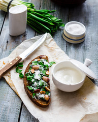 rye bread with wild garlic, sour cream and quail eggs and beans
