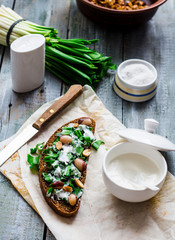 rye bread with wild garlic, sour cream and quail eggs and beans