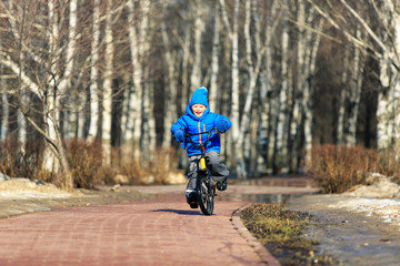 little boy enjoying bike ride in spring