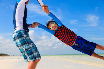 father and son playing on summer beach