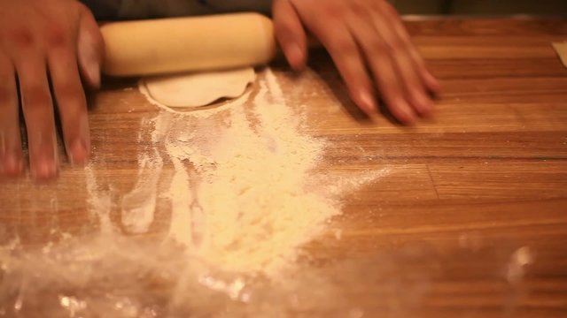 male chef hands preparing dough with rolling pin for asian food