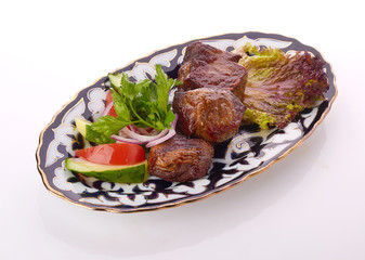 Meat on a grill with vegetables