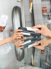 Customer Paying Through Smartphone At Butcher's Shop