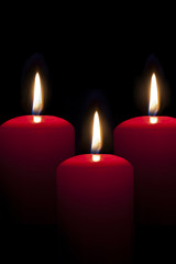 red candles lighting in the darkness