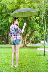 Portrait of beautiful young woman with umbrella in garden park