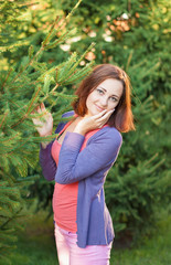 Portrait of a girl in a park near a Christmas tree.