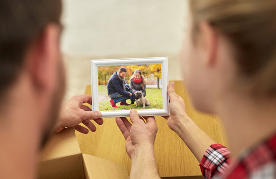 close up of happy couple looking at family photo