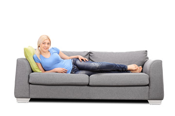 Pretty woman lying on a modern gray sofa