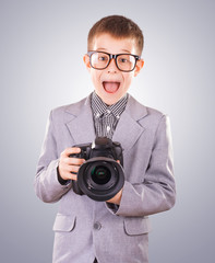 Fototapeta premium kid holding a dslr camera on a blue background